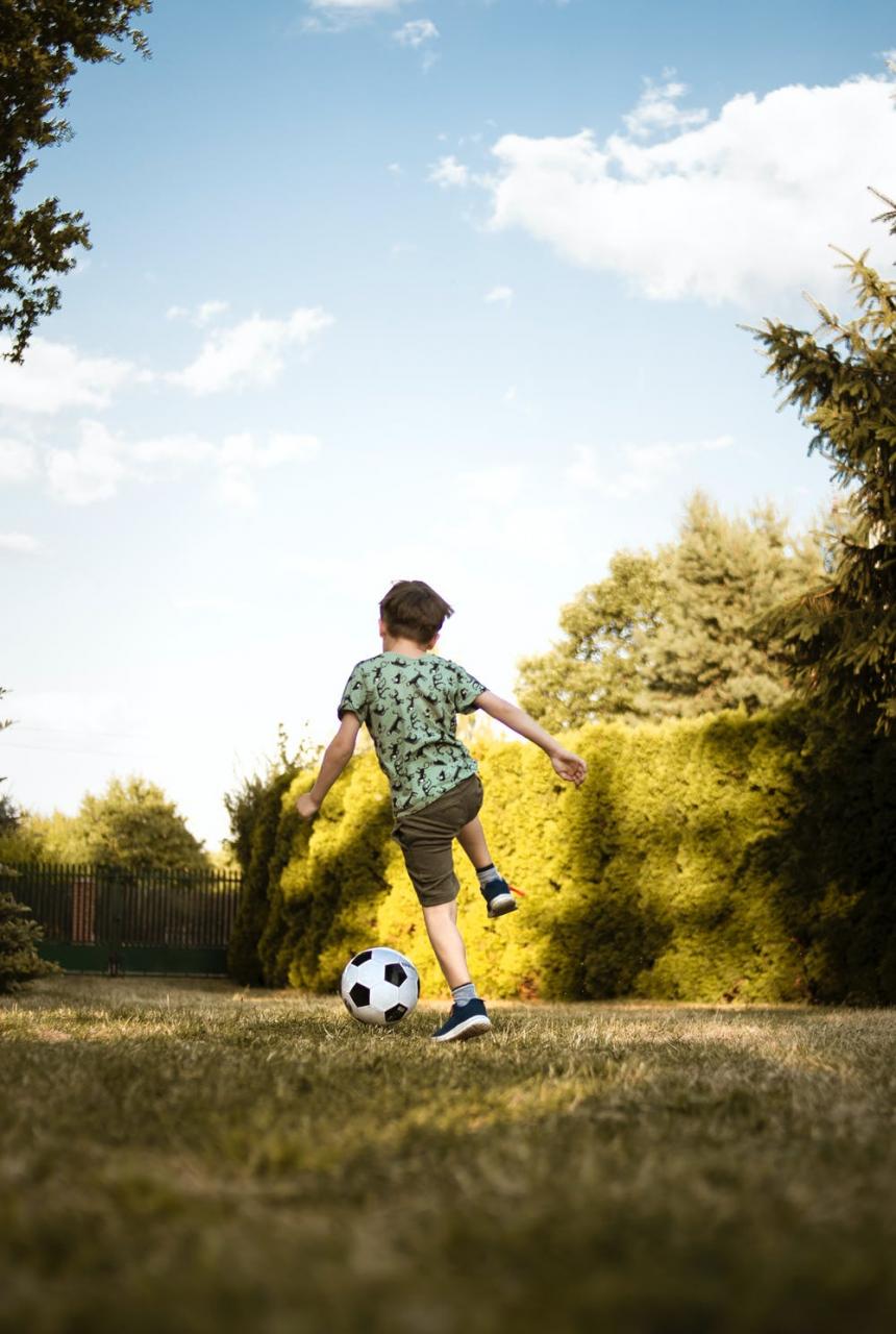 child playing soccer in an open field